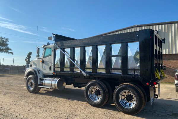 A large white truck with a black and silver dump body