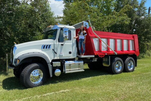A large white truck with a red and silver dump body