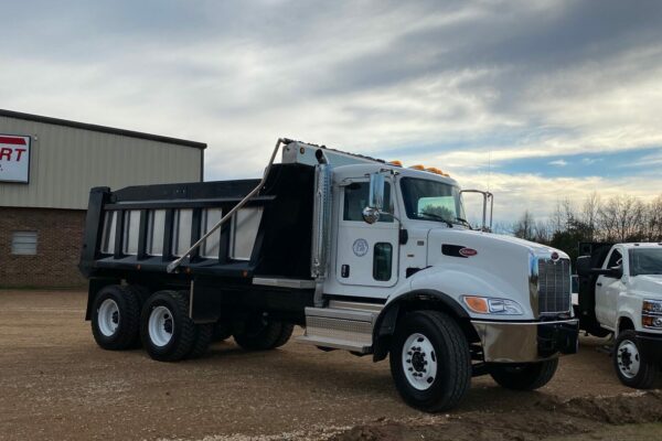 A large white truck with a black and silver dump body