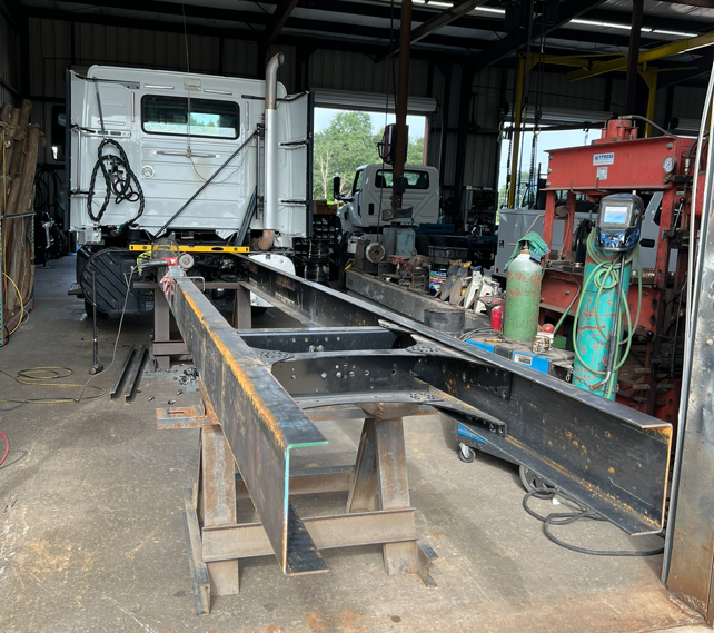 A truck with an exposed wheelbase receiving modifications